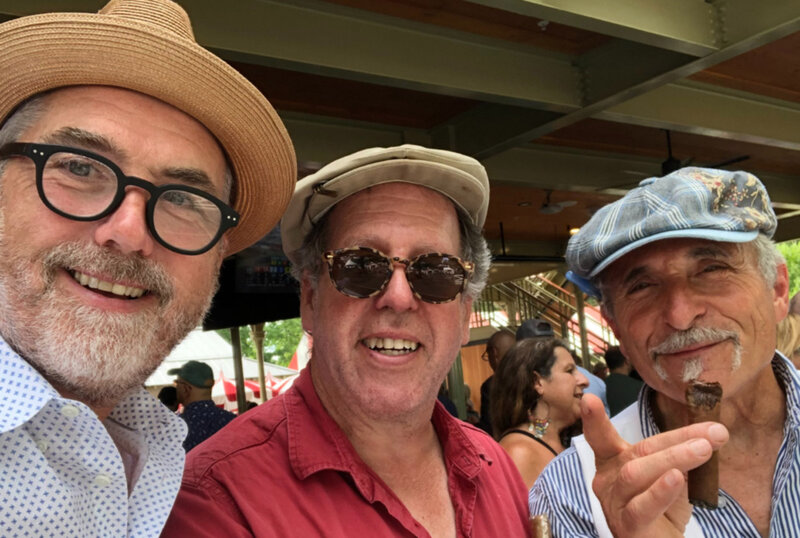 Three men smiling side by side