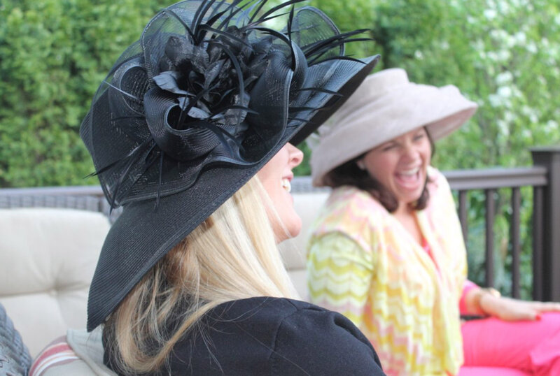 Women smiling wearing wide brim hats