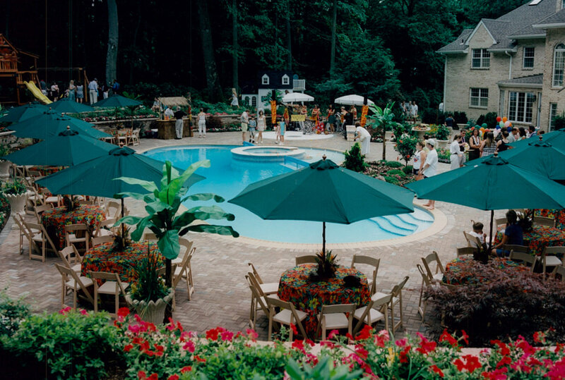 Pool with many set tables with green umbrellas