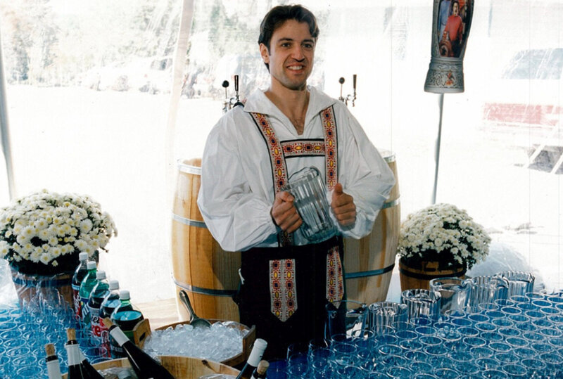 Bar tender wearing lederhosen holding pitcher