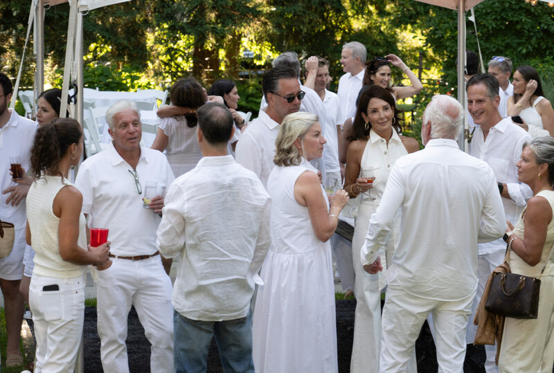 Group of party guests all dressed in white